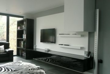 Fitted minimal white media cabinetry in open plan living area